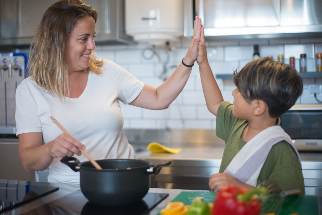 Criança ajudando a preparar legumes na cozinha em família